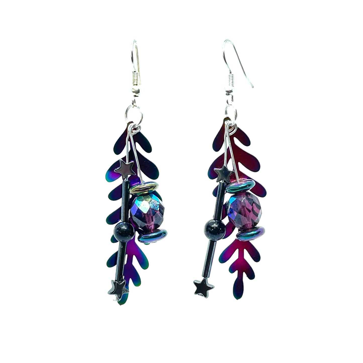 Colorful rainbow dangle earrings that are handmade and feature hematite stone stars and a metal rainbow leaf