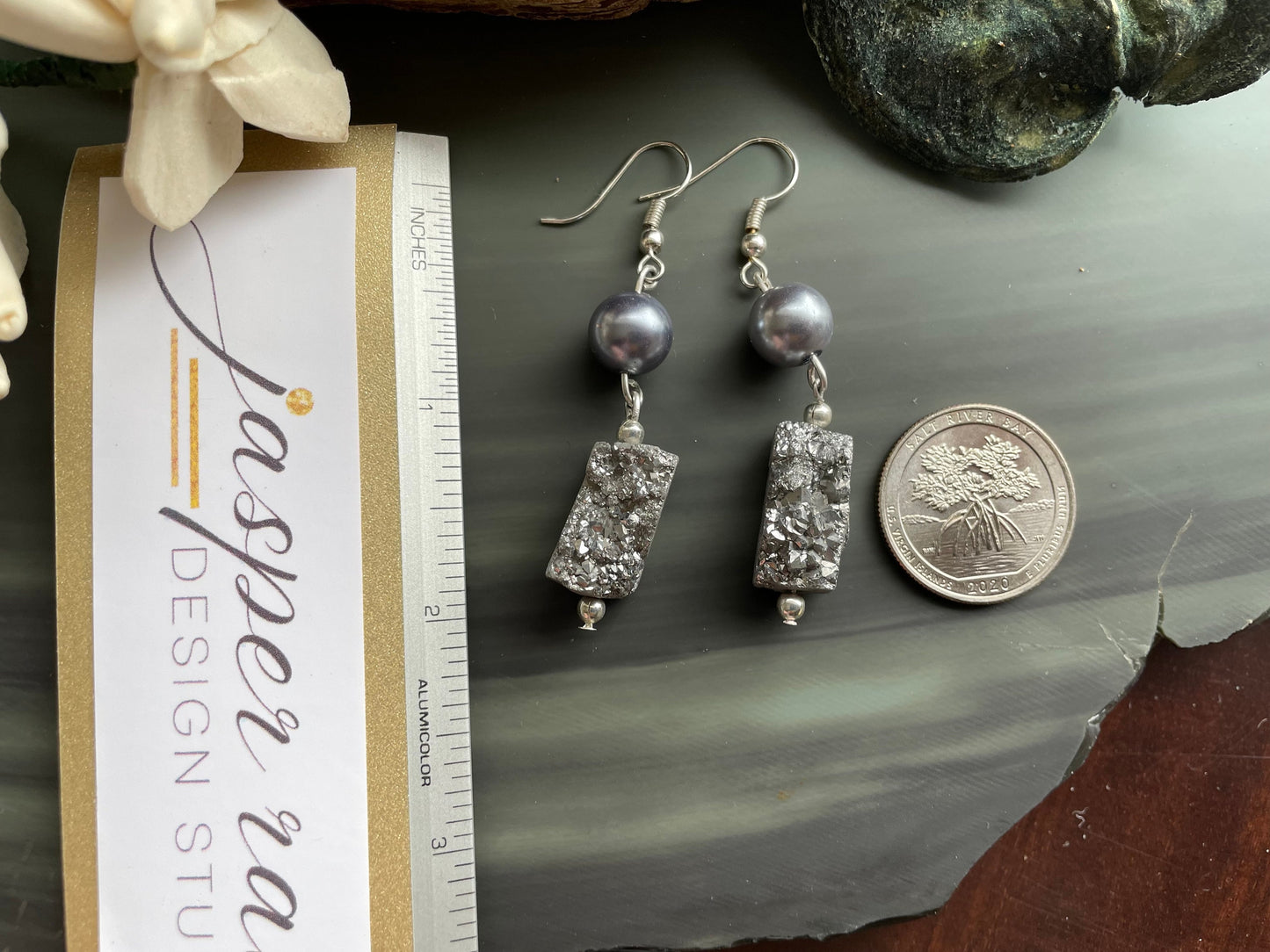 Platinum Druzy earrings with silver round pearl beads laying next to a ruler and quarter. The earrings are 2 inches long.